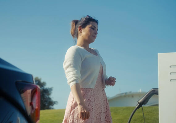 Female Deakin student charging electric vehicle