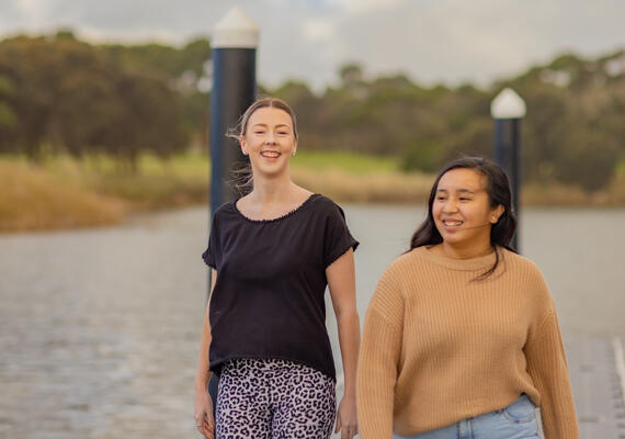 Two people walk on a pier in Warrnambool.