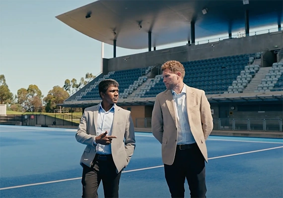 Two Deakin sport management students walking through a campus court.