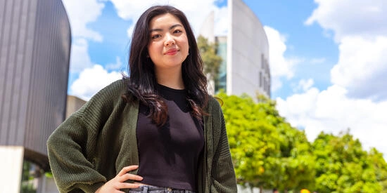 A Deakin student standing outside under a blue sky
