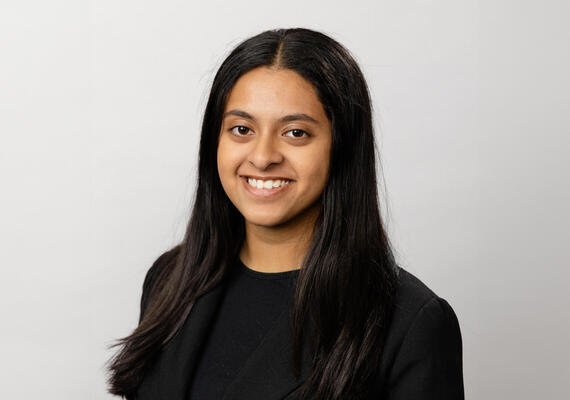 Smiling student against a plain backdrop