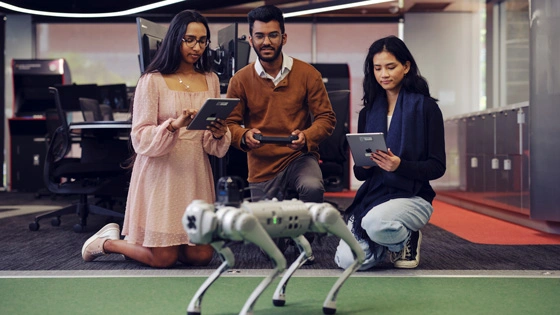 Software engineering students operating robot in RIoT lab.