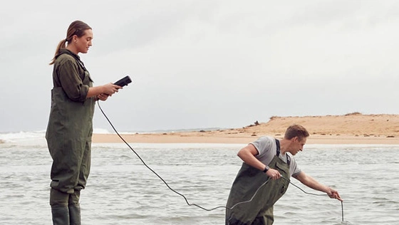 Two Deakin science students run tests in the ocean.