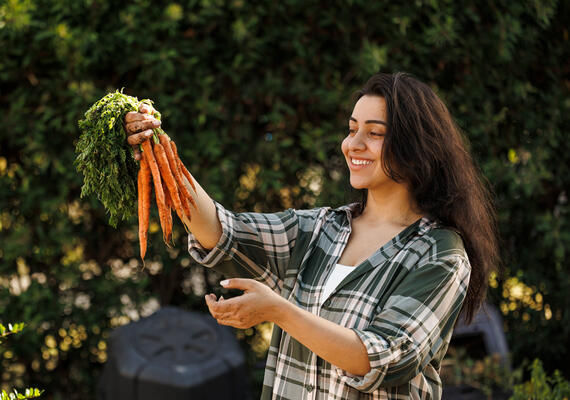 Food science student holding a bunch of carrots.