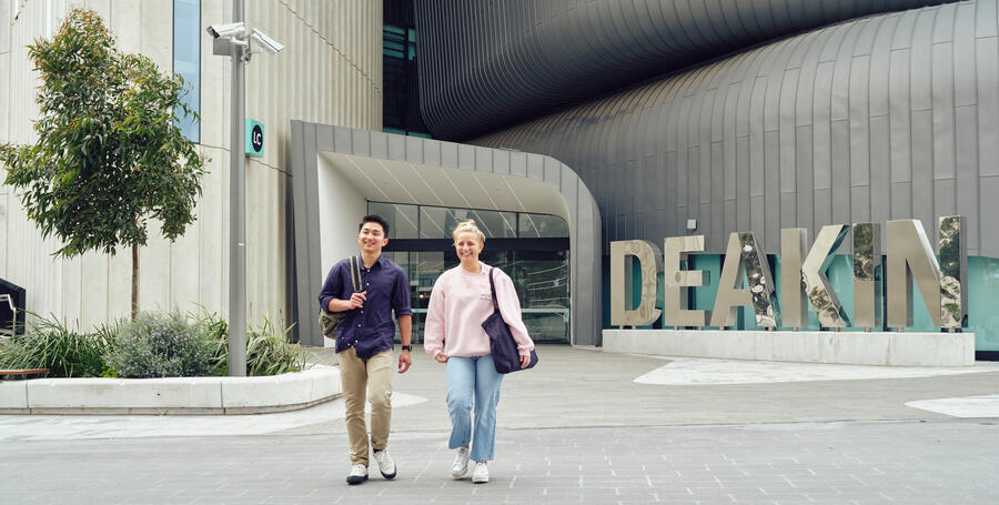 Two students walking in front of the Deakin Law School