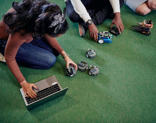 Aerial view of students working on the floor with robots