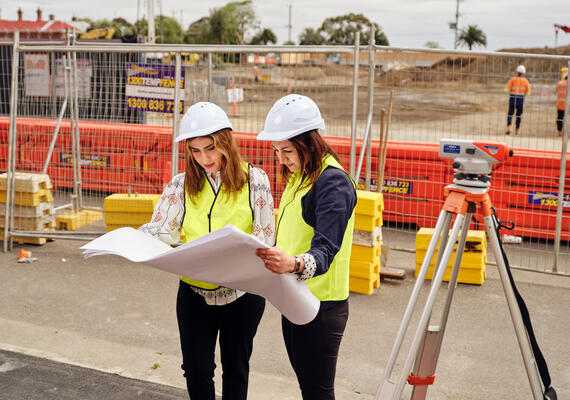Students onsite reviewing construction plans