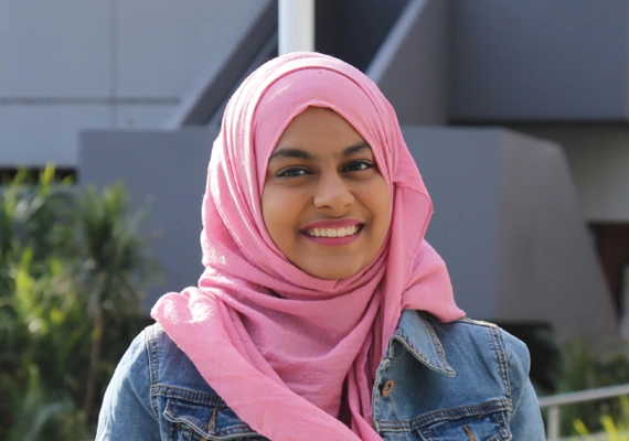 Deakin student mussfa stands and smiles to camera.