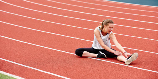 Student stretches on a running track at Waurn Ponds Campus.