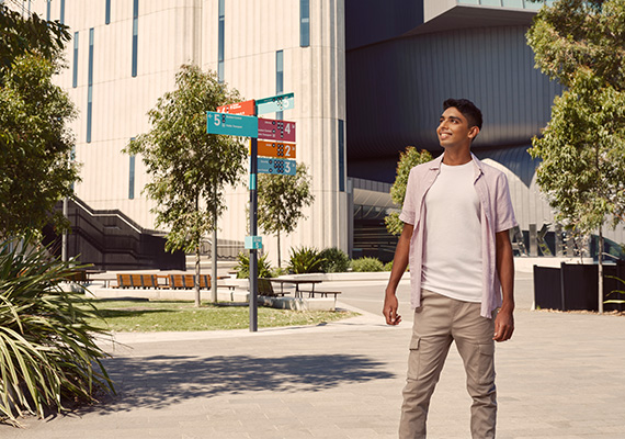 Deakin student stands outside at Geelong Waurn Ponds Campus.