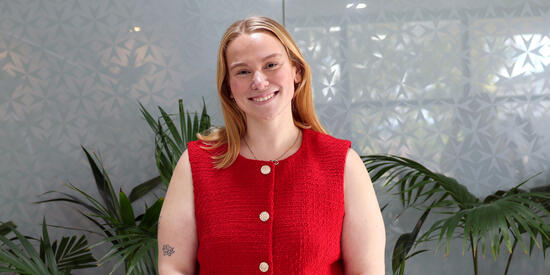 Deakin alumni and placement supervisor Marj Devereux smiling in front of wall on campus.