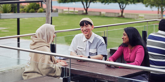Three Deakin international students socialise on the Geelong Waurn Ponds campus