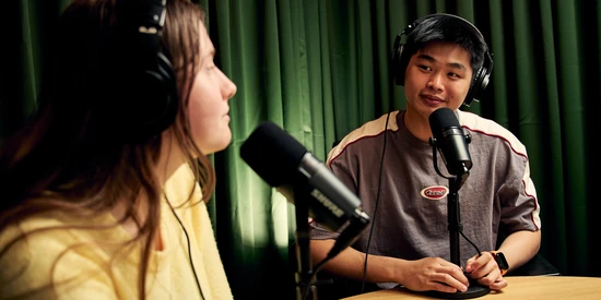 Two students sitting in podcast room
