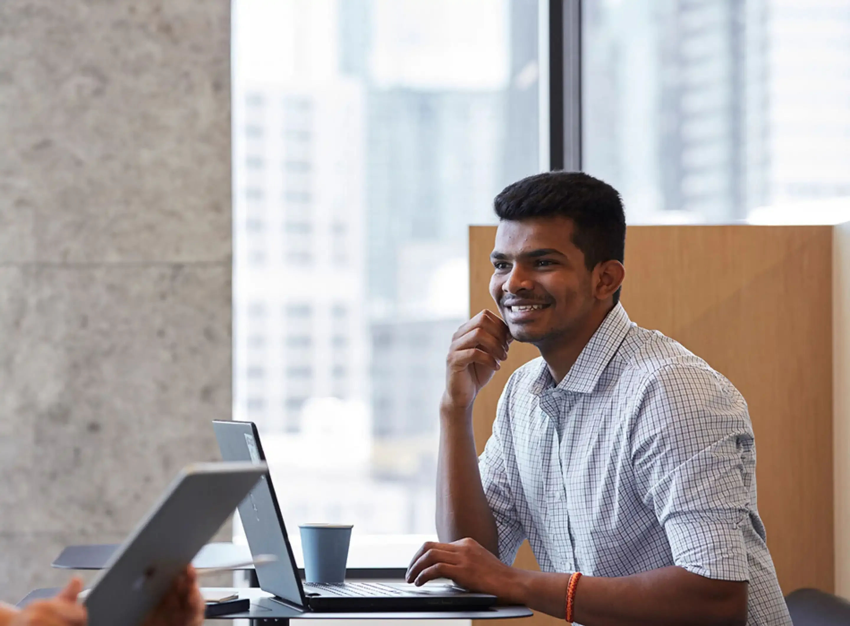 Student at computer looking at a book