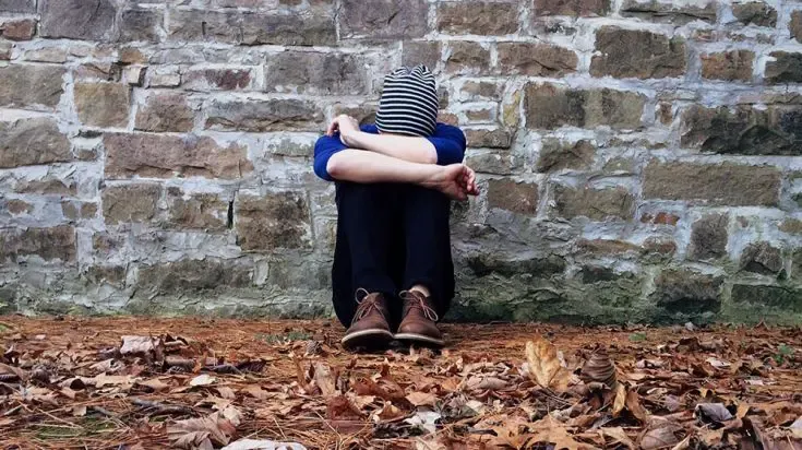Stressed person with head on knees