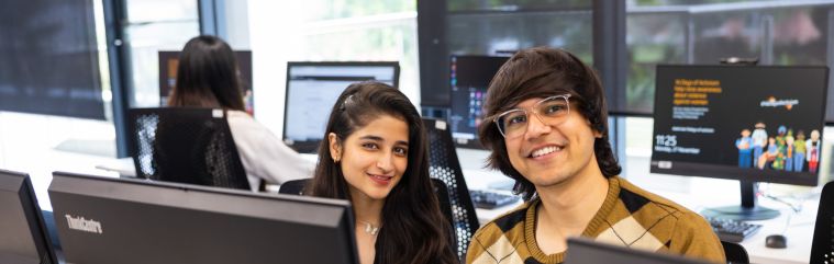 two people sitting behind computer