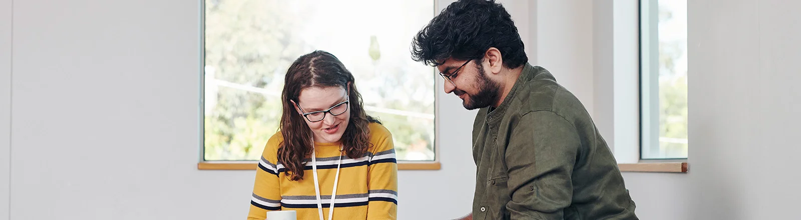 Two Deakin social work students sit talking. 