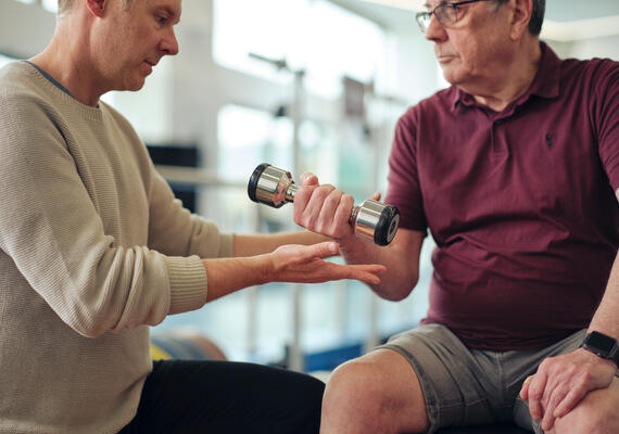 A health researcher and a person using a hand weight
