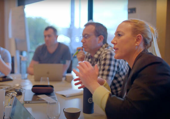 Three people sitting at a table having a discussion