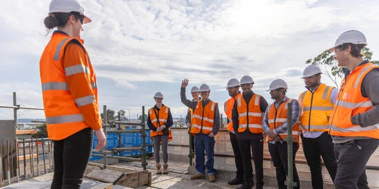 Engineering and construction management site tour group standing on roof top