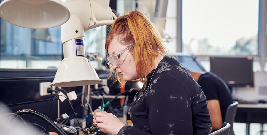 Student soldering in lab