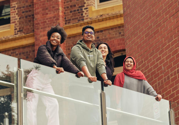 Four students on the balcony at Geelong Waterfront Campus