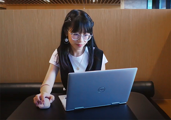 Student sitting at desk working on laptop.