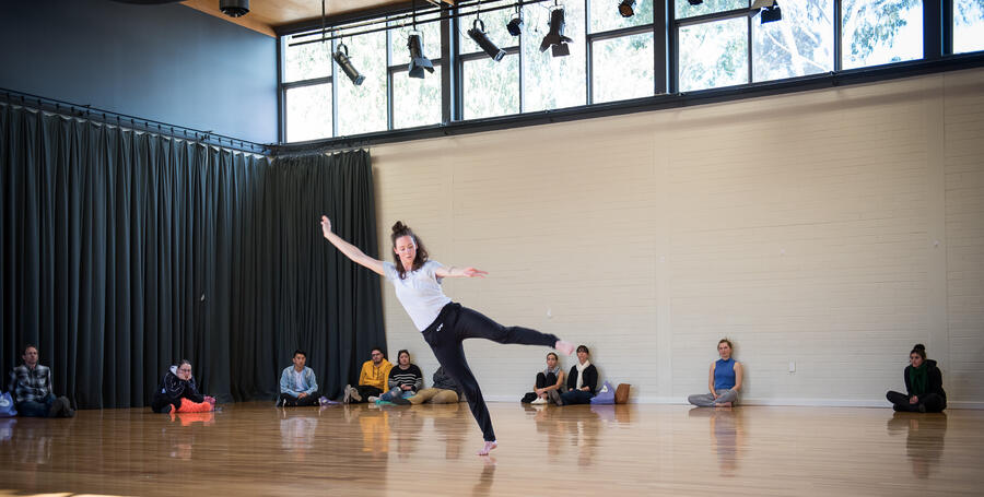 A Deakin student performing in the dance studio while other students watch
