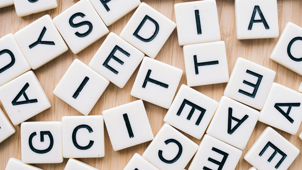 Image of a scrambled group of white tiles with black capital letters on them