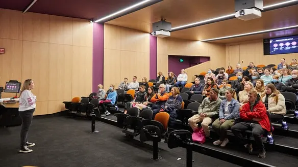 Parents and students sitting in a lecture theatre attending an information session at Open Day.
