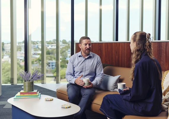 A counsellor sits on a couch with a client.