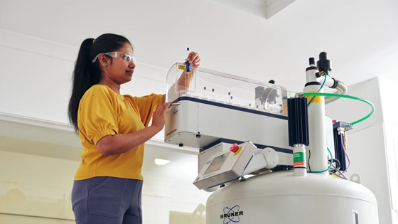 Phd Student manually loading NMR sample as part of the chemistry specialisation options in Bachelor of Science.