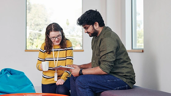 Two Deakin social work students sit talking. 