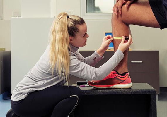 A student measuring a leg calf.