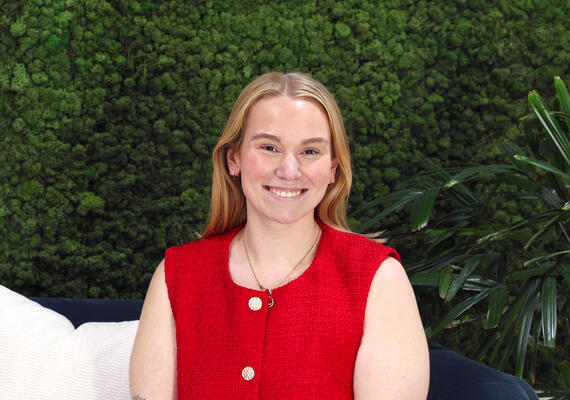 Deakin alumni and placement supervisor Marj Devereux smiling in front of wall on campus.