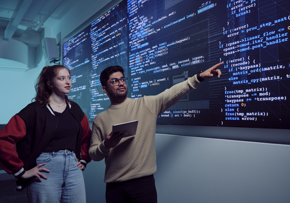Students discussing and analysing data in classroom with projection on large wall screen at Deakin's Melbourne Burwood Campus.