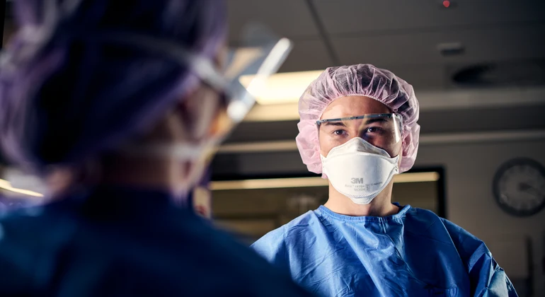 Deakin graduate diploma of perianaesthesia nursing student looks at camera in operating theatre.