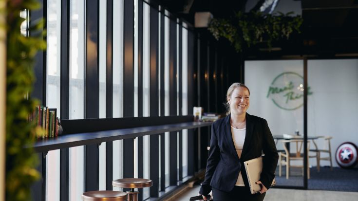 Female student walking in business attire in office