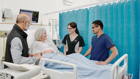 Deakin Master of Nursing students around a hospital patient bed.