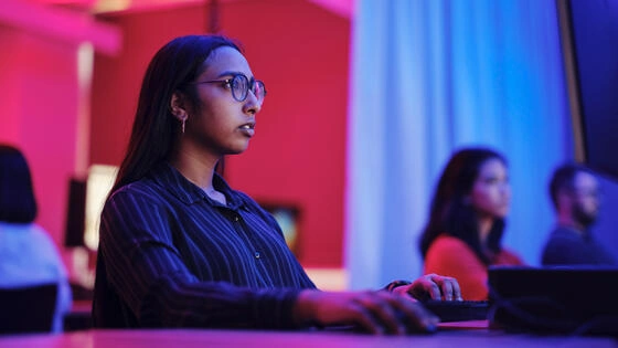 A Deakin postgraduate cyber security student works on a computer,
