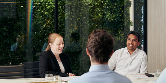 Group of Deakin Master of business administration students sit around table and talk.