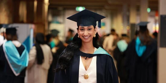 Student in a graduation cap and gown at Deakin Graduations at the Waterfront Campus.