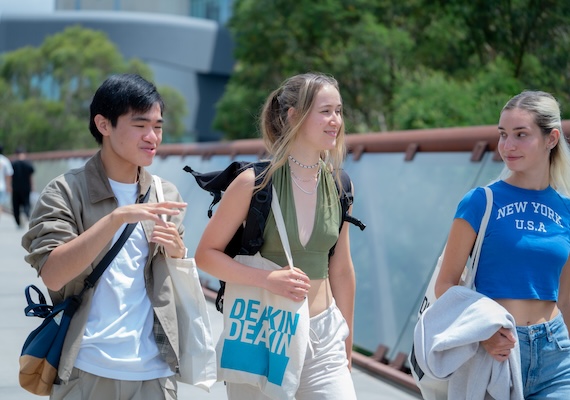Three study abroad and exchange students walking on campus.