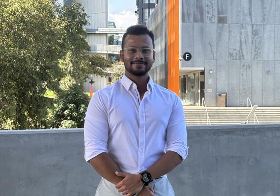 Deakin sport management student Diptagni standing and smiling.
