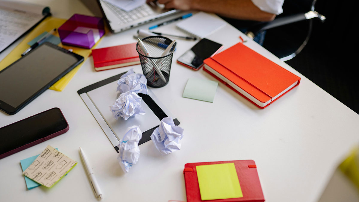 Image of a messy desk with crumpled pieces of paper