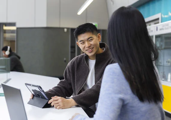 Student smiling while on tablet
