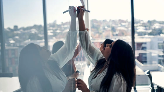 A Deakin Graduate Certificate of Artificial Intelligence for Business student writes on a whiteboard.
