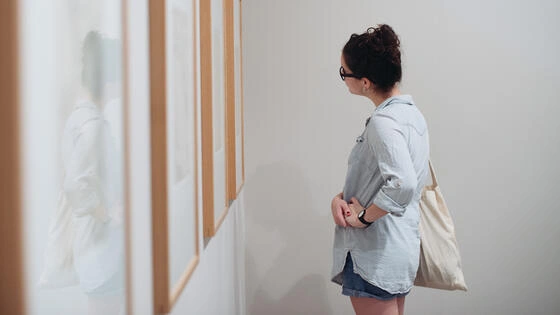 A Deakin postgraduate cultural heritage studies student looks at art work in a gallery.