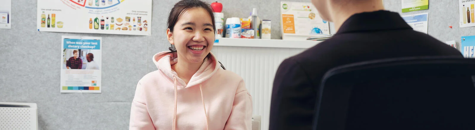 A Deakin postgraduate human nutrition students speaks to a young person in a clinic.