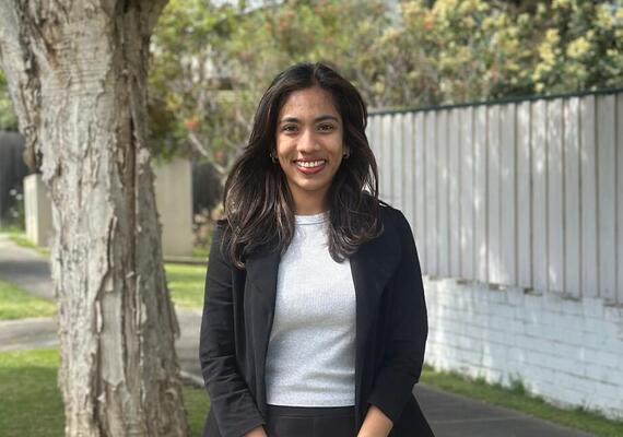 Master of International Relations Deakin student Shehara standing outside next to a tree, smiling at the camera.